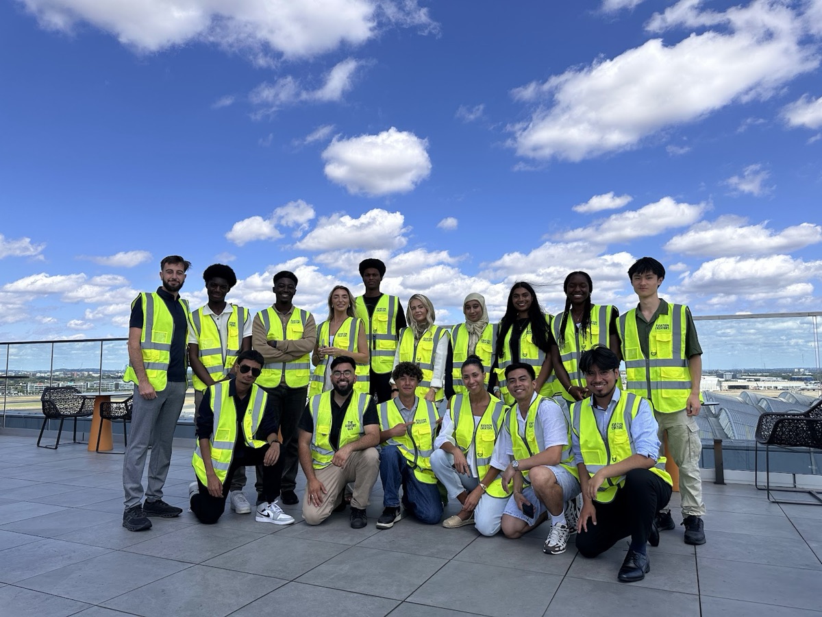 Creators in hi-vis vests on an airport rooftop