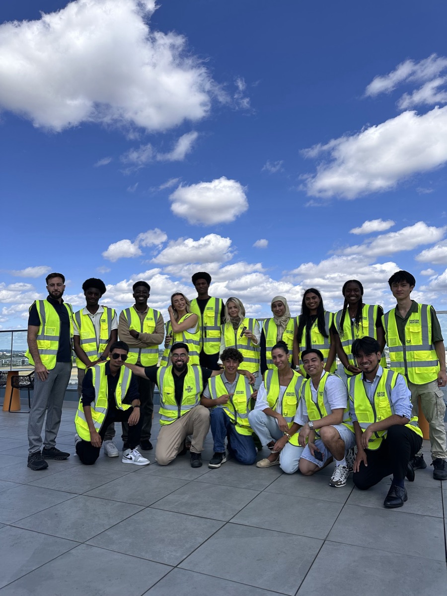 A group of creators in hi-vis under a blue sky, airside